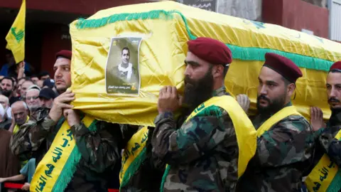 Reuters Hezbollah members carry the coffin, dressed in yellow, of Hassan Youssef Abdel Sater who was killed on Friday in an Israeli attack in the southern suburbs of Beirut.