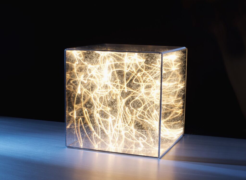 Light trails and sparks are trapped in a clear plastic box in this conceptual illustration.